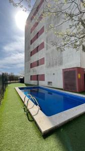 uma piscina em frente a um edifício em Apartamento acogedor con piscina en Santa Margarita em Roses