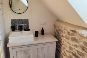 een badkamer met een wastafel en een spiegel bij Gîte Le Cabestan à la mer Lingreville in Lingreville