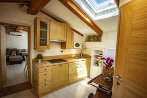 a kitchen with wooden cabinets and a skylight at Toncevi Eco Estate in Branik