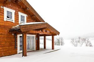 a wooden cabin in the snow with snow on it at Lake View Apartment 2 bedrooms in Sykkylven
