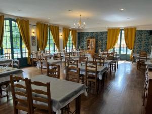 Le Chambellan في Coux-et-Bigaroque: غرفة طعام مع طاولات وكراسي وستائر صفراء