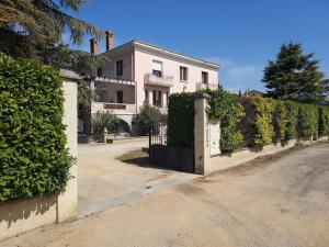 a white house with a gate and a hedge at Appartement entier, jacuzzi et parc in Orange