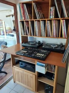 une étagère remplie de disques et d'un clavier dans l'établissement Loft ravissant avec jacuzzi et parc, à Orange