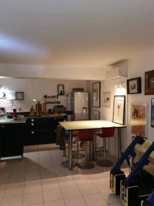 uma cozinha com uma mesa e uma cozinha com um frigorífico em Loft ravissant avec jacuzzi et parc em Orange