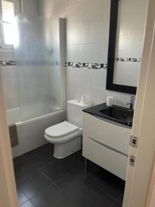een badkamer met een toilet, een douche en een wastafel bij ático con terraza- solarium in Écija