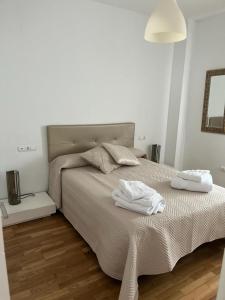 een slaapkamer met een bed met twee witte handdoeken erop bij ático con terraza- solarium in Écija