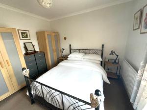 a bedroom with a large bed with white sheets at George Street Beverley in Beverley