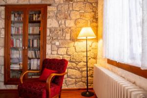 een woonkamer met een rode stoel en een lamp bij Marvelous Stonehouse With Backyard and Fireplace in Alacati Cesme in Alacati