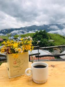 uma chávena de café sentada numa mesa com flores em Tsikhis Dziri em Omalo