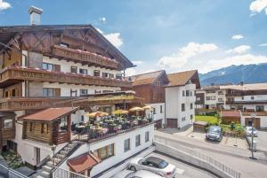 een gebouw met een balkon waar auto's voor geparkeerd staan bij Tirolerhof - Super Sommer Card included in Serfaus