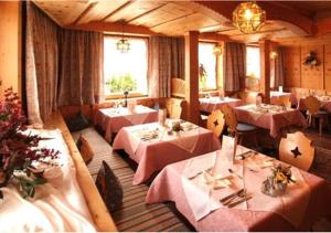 a restaurant with several tables with pink tablecloths at Tirolerhof in Serfaus