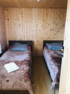 Duas camas num quarto com paredes de madeira em Tsikhis Dziri em Omalo