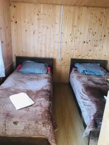 Duas camas num quarto com paredes de madeira em Tsikhis Dziri em Omalo