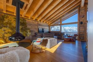 ein Wohnzimmer mit einem Kamin und einem großen Fenster in der Unterkunft Le Grimpeur, Mer de Glace Spa Access, 50m from ski lift in Nendaz