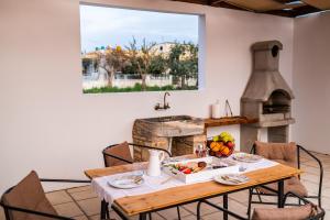 una sala da pranzo con tavolo e forno per pizza di Paradisi Stone House a Città di Kos