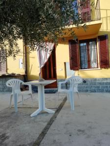einen Tisch und zwei Stühle vor einem Gebäude in der Unterkunft L'ulivo,casa di campagna. in Cortiglione