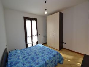 a bedroom with a blue bed and a window at Spacious apartment close to the beach - Beahost in Rosolina Mare