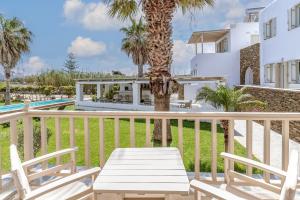 a deck with a table and chairs on a resort at Ninemia Suites Tinos Grand 104 in Kionia