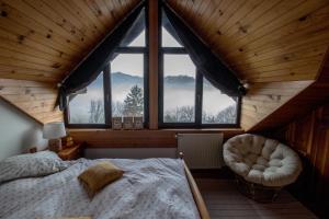 Un dormitorio con una cama y una ventana grande en Wooden fairytale, en Lesično