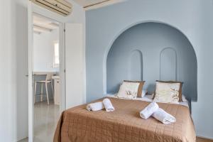 a bedroom with a bed with two towels on it at Ninemia Suites Tinos Grand 104 in Kionia