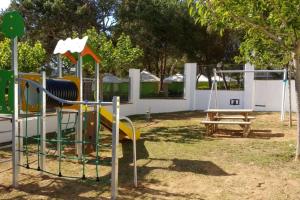 un parque infantil con tobogán y columpio en Kampaoh Palamós Internacional, en Palamós