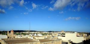 a view of a city under a blue sky at A charming and cosy townhouse in a quaint village in Sannat