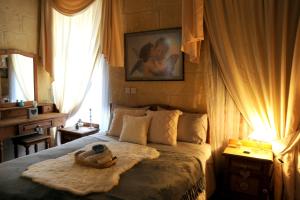 een slaapkamer met een bed met een hoed erop bij A charming and cosy townhouse in a quaint village in Sannat