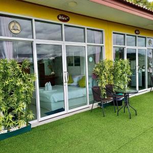 a building with a patio with a table and chairs at Phuyafahsai The Resort Khao Kho in Khao Kho