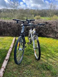 een fiets geparkeerd op het gras in een veld bij The Grey Tiny in Chimay