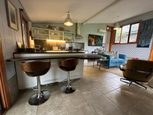 a kitchen with a counter and two bar stools at The Studio - Yarra Valley in Yarra Glen