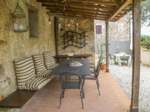 a patio with a table and chairs and a couch at Iesa - Relax nella campagna di Siena in Lama