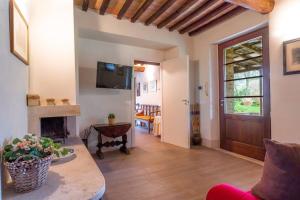 a living room with a fireplace and a television at Iesa - Relax nella campagna di Siena in Lama