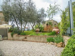 a backyard with a garden with trees and a fence at Iesa - Relax nella campagna di Siena in Lama