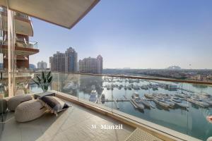 a balcony with a view of a harbor with boats at Manzil - Lavish 3BR resort with private beach at Tiara Residence Palm Jumeirah in Dubai