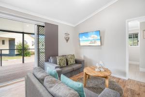 un soggiorno con divano e tavolo di Fraser Island Beach Houses a Fraser Island
