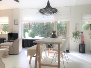 a living room with a dining room table and chairs at The Forest Lodge in Otterlo