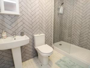 Un baño con inodoro, lavabo y ducha. en 50A Lloyd Street West, en Llandudno 16 fotos más