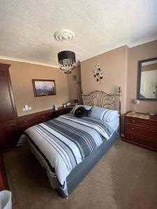 a bedroom with a large bed and a chandelier at Minton cottage in Leadhills