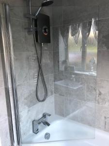 a bathroom with a shower with a sink at Minton cottage in Leadhills