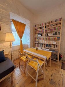 a dining room with a table and chairs and bookshelves at Casa Petri Rosia Montana in Roşia Montană