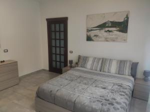 una camera da letto con un letto e un dipinto sul muro di Bidda Mores Appartamenti- Il Cacciatore a Capoterra