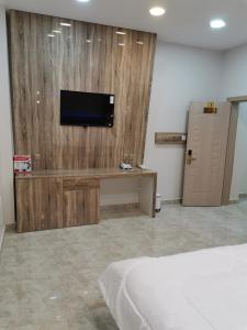 Habitación con TV en una pared de madera. en مارينا للغرف الفندقية, en Sohar