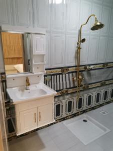 a white bathroom with a sink and a shower at مارينا للغرف الفندقية in Sohar