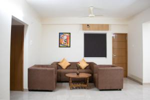 ein Wohnzimmer mit einem Sofa und einem Tisch in der Unterkunft Richinn Palace home stay in Chennai
