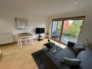 a living room with a couch and a table at Lovely studio Apartment with balcony in Norwich