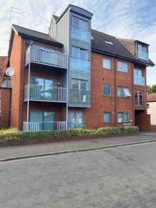 um grande edifício de tijolos ao lado de uma rua em Lovely studio Apartment with balcony em Norwich