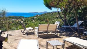 drewniany taras z 2 krzesłami i stołem w obiekcie maison-a-sulana-palombaggia w mieście Porto-Vecchio