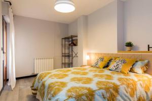 sypialnia z dużym łóżkiem z żółtymi poduszkami w obiekcie Castrillo 4 Apartamento Acogedor w Saragossie
