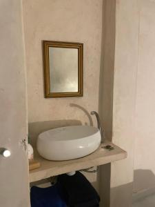 a bathroom with a sink and a mirror on a counter at Kasbah’s road Art house in Tangier