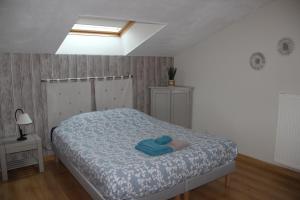 1 dormitorio con 1 cama con manta azul en Aux trois petites notes, en La Sabotterie